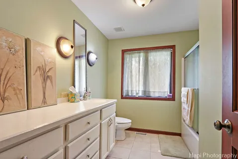 a bathroom with a double vanity sink mirror and a toilet