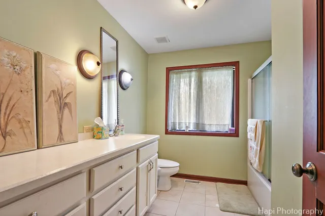 a bathroom with a double vanity sink mirror and a toilet