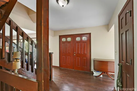 a view of a hallway with wooden floor and living room