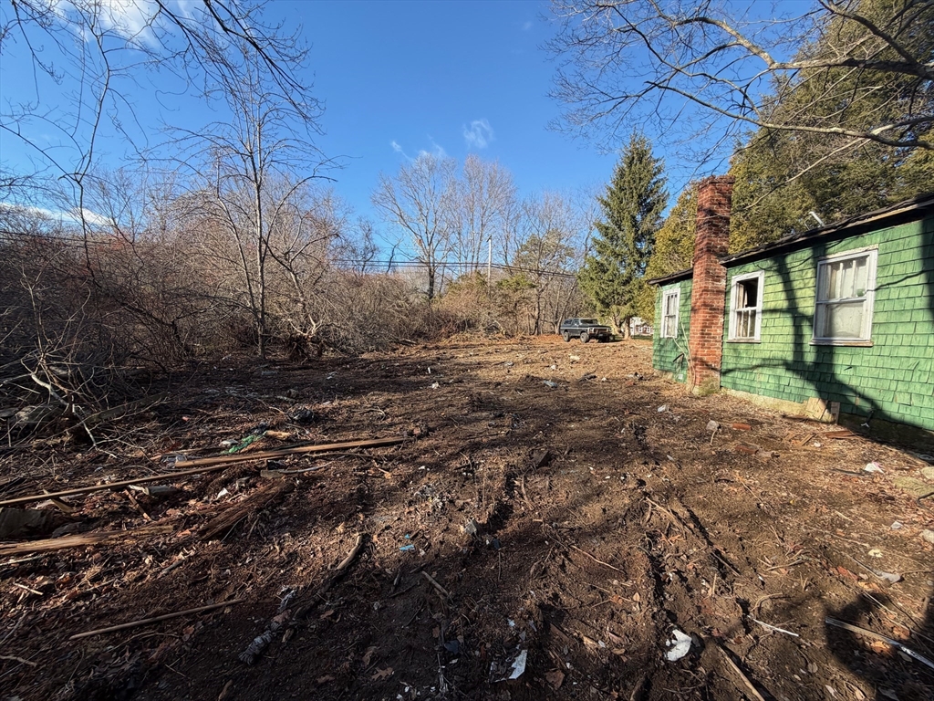 44 Federal Street Blackstone, MA 01504 - Photo 7 of 20 a view of a yard with plants and a large tree