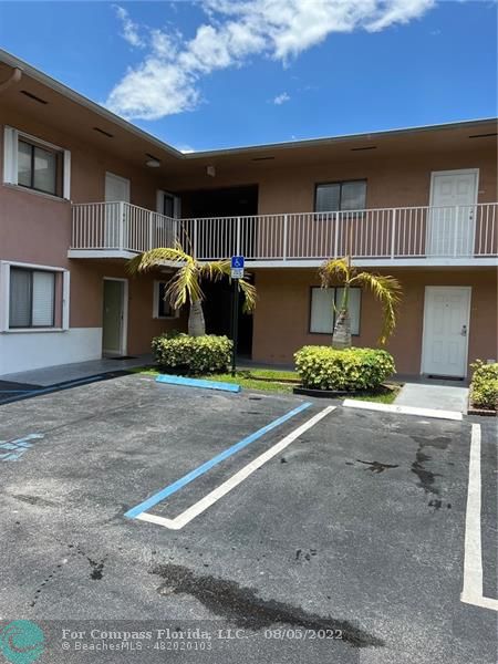 6041 West 24th Avenue, Unit 101 Hialeah, FL 33016 - Photo 1 of 8 a front view of a building with garden space and a garage