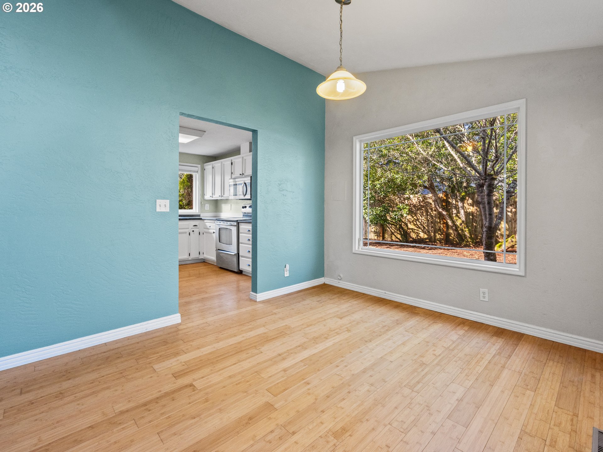2066 40th Street Florence, OR 97439 - Photo 16 of 48 an empty room with wooden floor a ceiling fan and windows