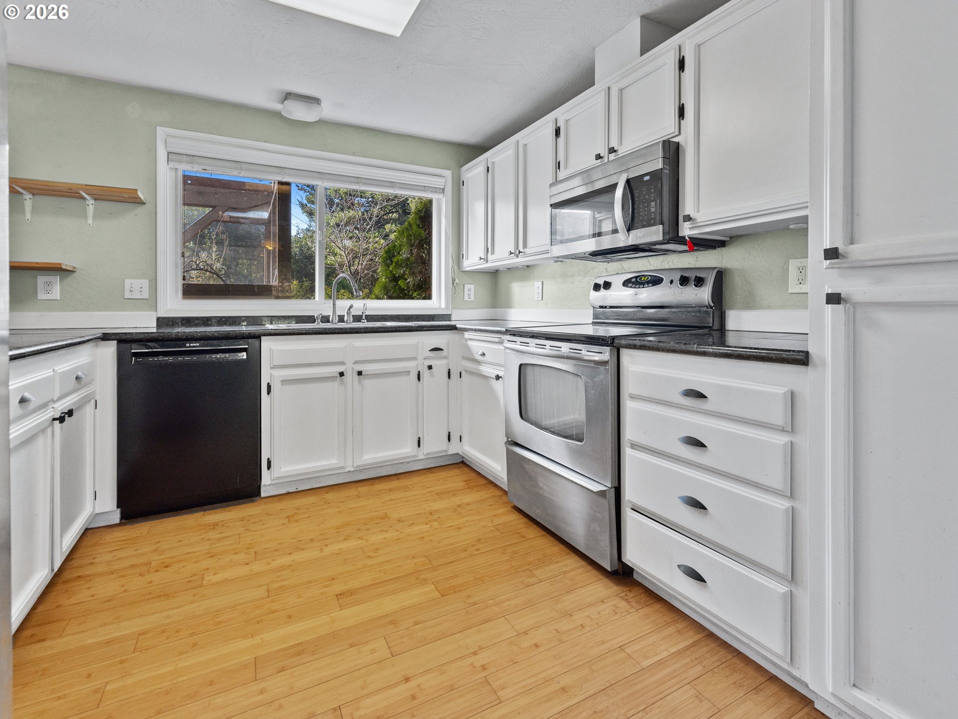 2066 40th Street Florence, OR 97439 - Photo 19 of 48 a kitchen with stainless steel appliances granite countertop a stove a sink and white cabinets