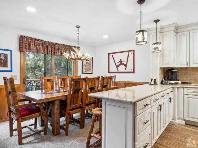 a kitchen with granite countertop a stove top oven a sink a dining table and chairs