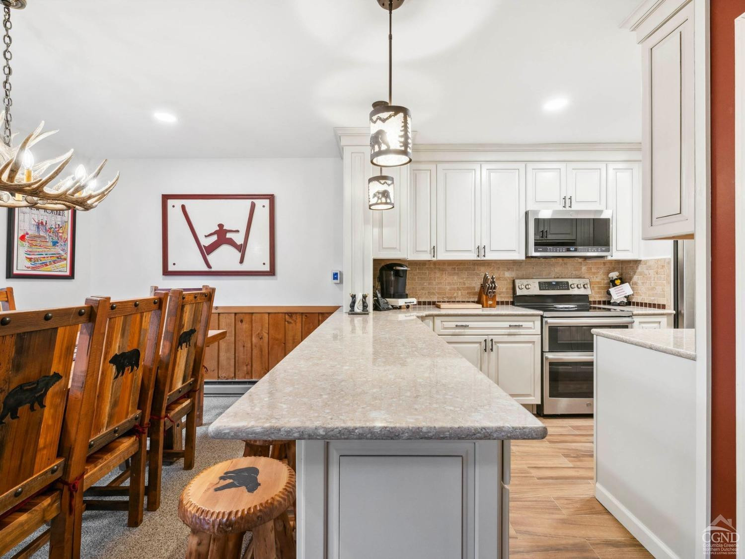 57 Brainard Ridge Road, Unit 3E Windham, NY 12496 - Photo 15 of 55 a kitchen with granite countertop a stove top oven a sink a dining table and chairs