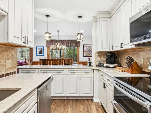 a room with table chairs and kitchen view