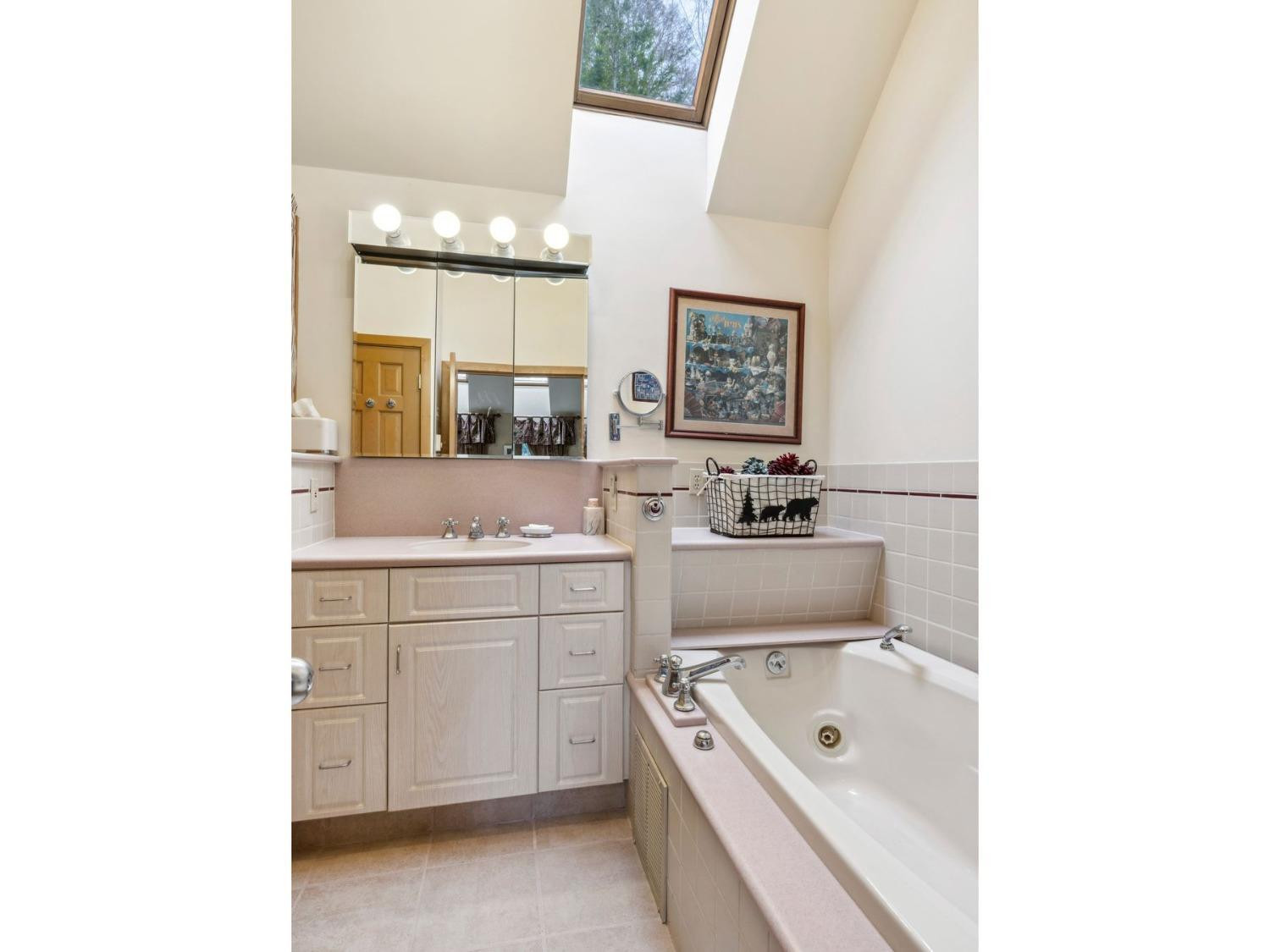 57 Brainard Ridge Road, Unit 3E Windham, NY 12496 - Photo 38 of 55 a bathroom with a sink a bath tub a mirror and a bathtub