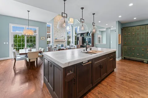 a large kitchen with kitchen island granite countertop a stove a sink a island and chairs