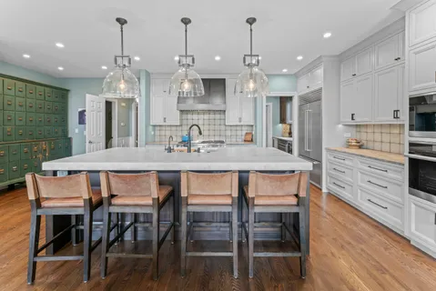 a kitchen with granite countertop a table chairs stainless steel appliances and cabinets