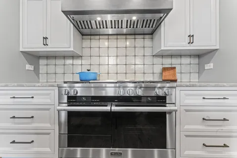 a kitchen with granite countertop white cabinets and stove