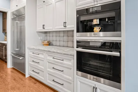 a kitchen with white cabinets and appliances