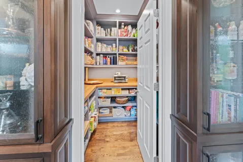 a view of a hallway with wooden shelves