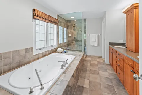 a bathroom with a tub sink and mirror
