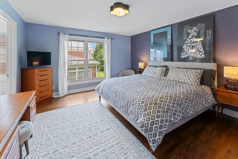 a bedroom with a bed and a television on dresser