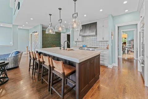 a kitchen with stainless steel appliances granite countertop a kitchen island a stove a table and chairs