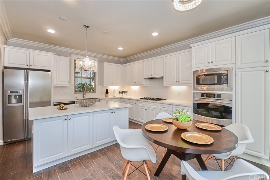 39 Conservancy Irvine, CA 92618 - Photo 8 of 32 a kitchen with stainless steel appliances granite countertop a sink a stove a dining table and chairs