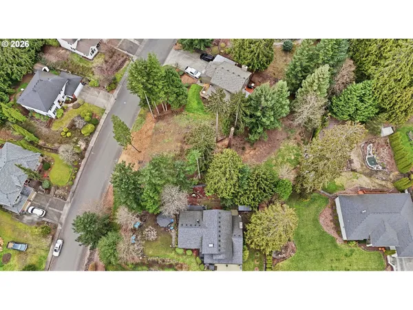 an aerial view of a house with a yard and greenery