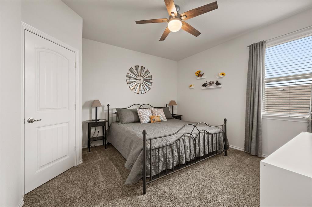 15817 White Mill Road Fort Worth, TX 76177 - Photo 21 of 27 a bedroom with a bed and a chandelier