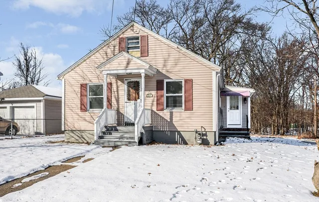 a front view of a house with a yard covered in snow