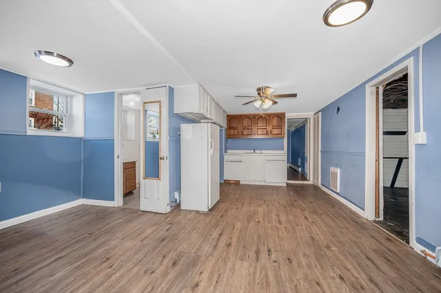 a view of a kitchen with a refrigerator wooden floor and a ceiling fan