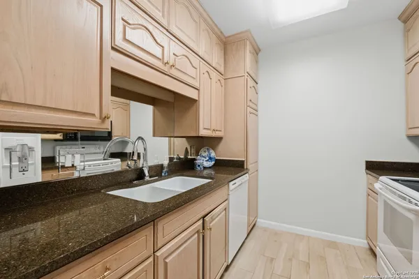 a kitchen with a sink cabinets and a wooden floor
