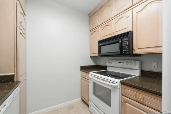 a kitchen with granite countertop white cabinets stainless steel appliances and a sink