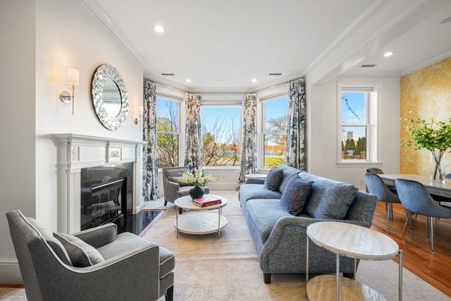a living room with furniture a fireplace and a large window