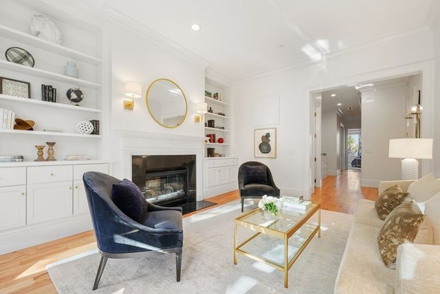 a living room with furniture a fireplace and a potted plant