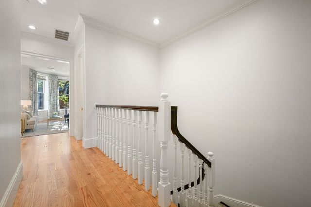 a view of a hallway with wooden floor and staircase