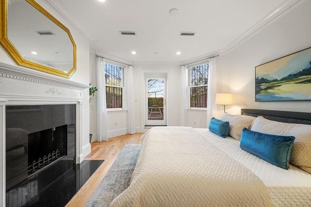 a spacious bedroom with a large bed a fireplace and a window