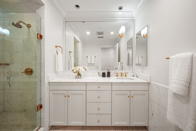 a bathroom with a double vanity sink mirror and shower