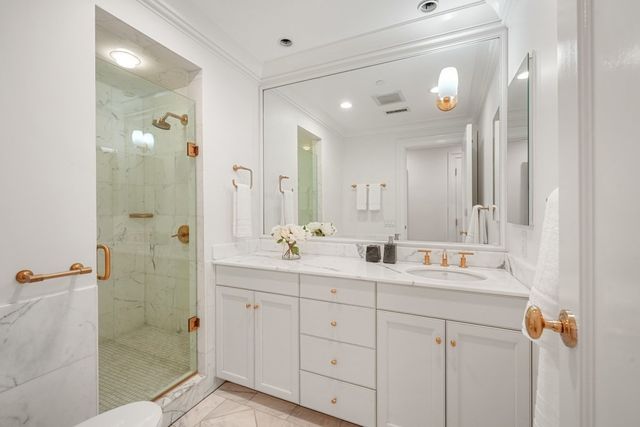a bathroom with a double vanity sink mirror and shower