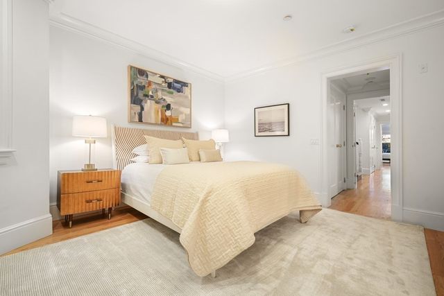 a bedroom with a bed and a painting on the wall