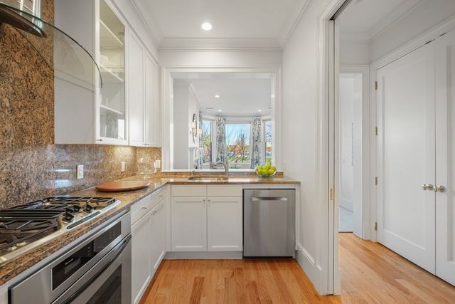 a kitchen with stainless steel appliances a stove and wooden floor
