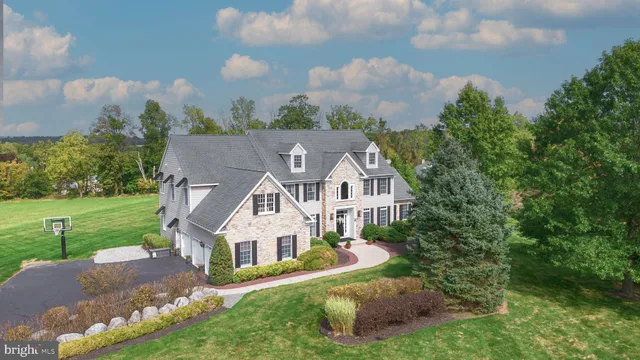 a view of a house with a big yard plants and large trees