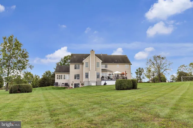a view of a house with a big yard and large trees