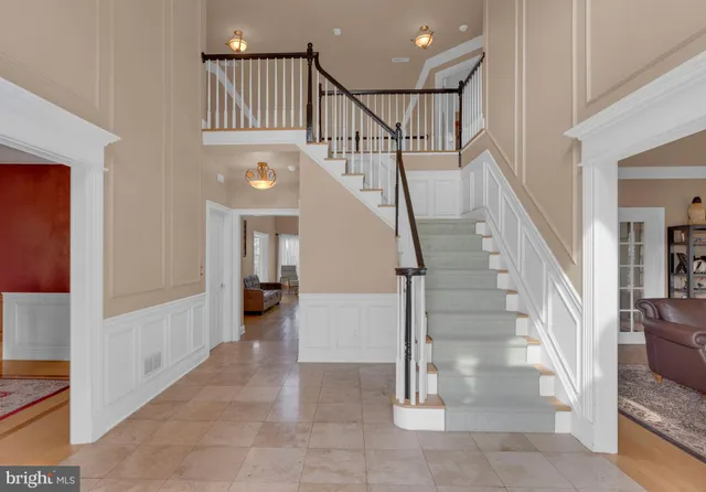 a view of a white house with a big yard plants and large trees