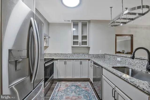 a kitchen with kitchen island a counter space a sink appliances and cabinets