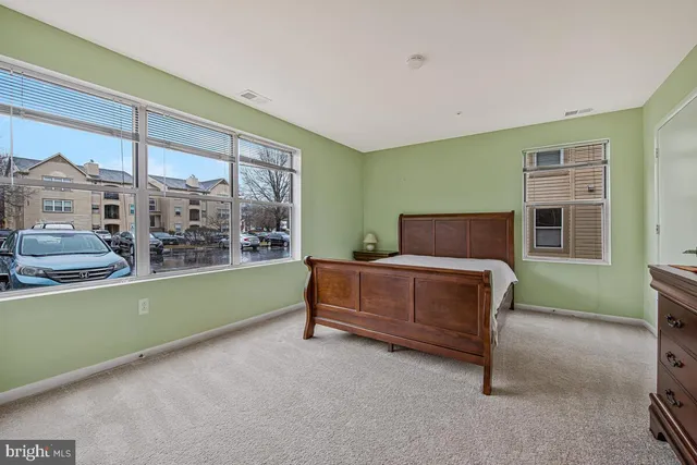 a bedroom with a large bed and wooden floor