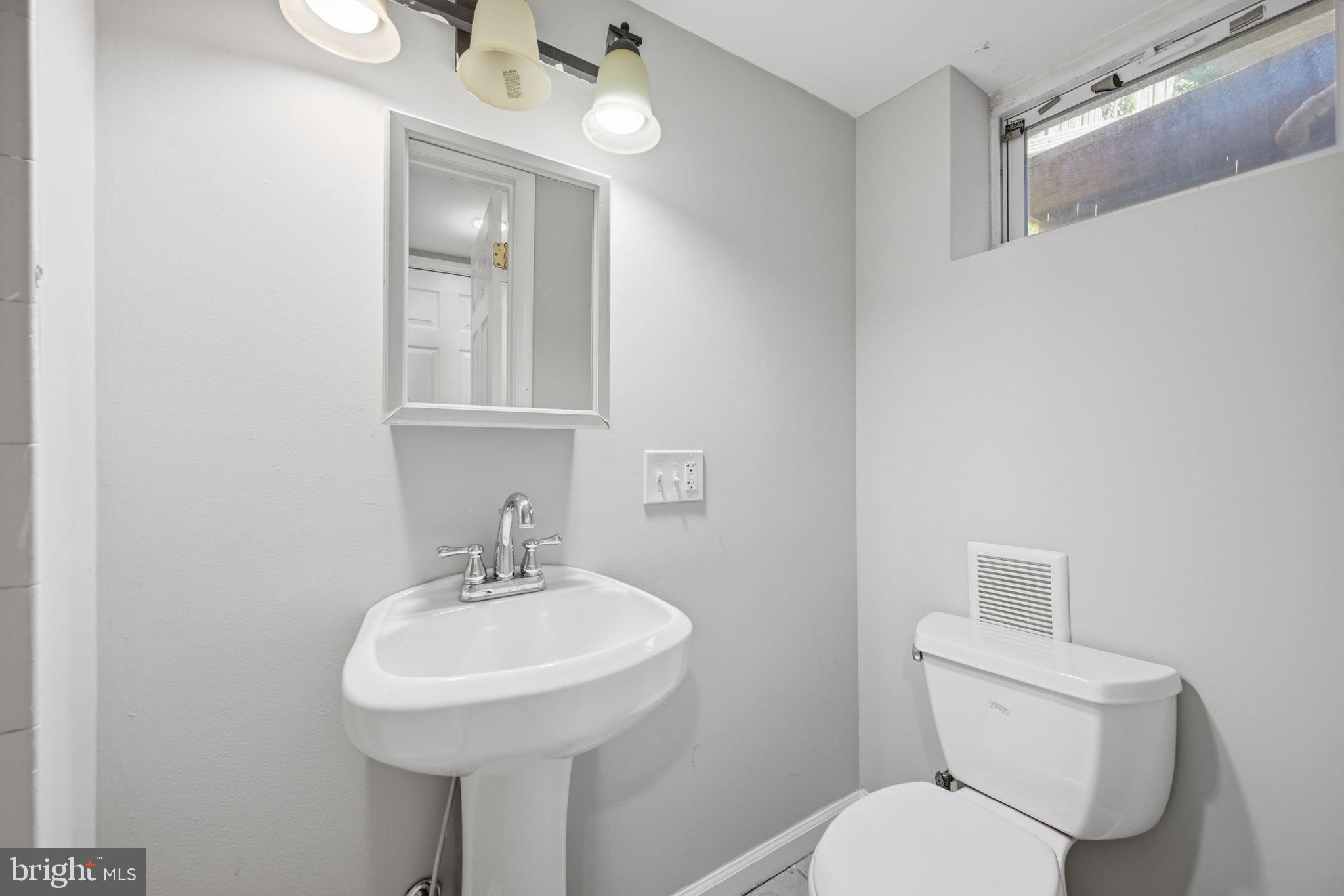 3723 Yolando Road Baltimore, MD 21218 - Photo 22 of 42 a bathroom with a toilet sink and mirror