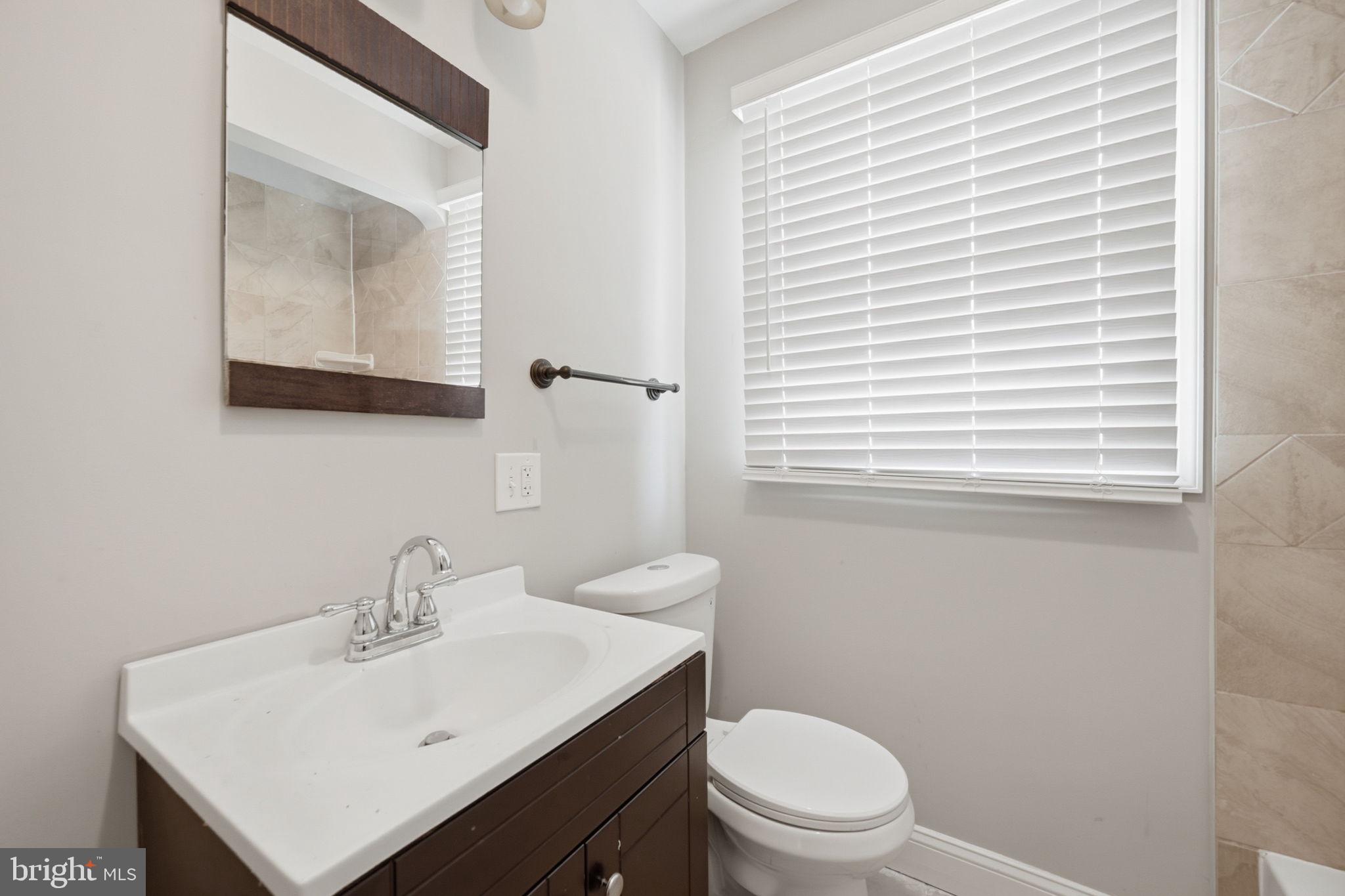 3723 Yolando Road Baltimore, MD 21218 - Photo 33 of 42 a bathroom with a toilet a sink and mirror
