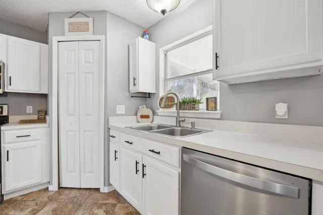 a kitchen with kitchen island granite countertop a sink and a stove top oven with wooden floor