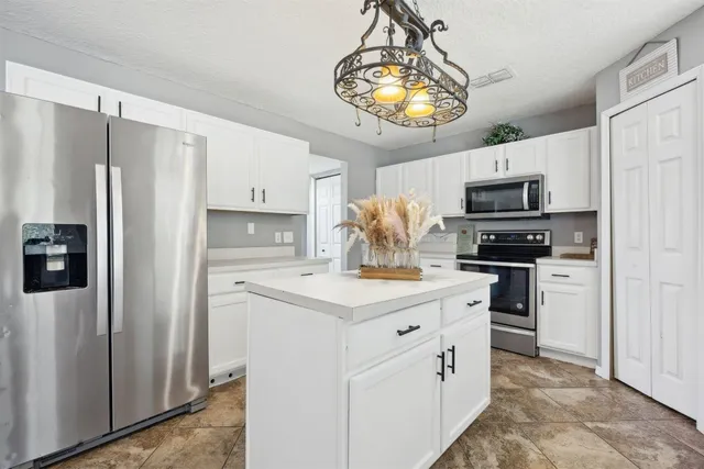 a kitchen with stainless steel appliances granite countertop white cabinets and black stove top oven with granite countertops