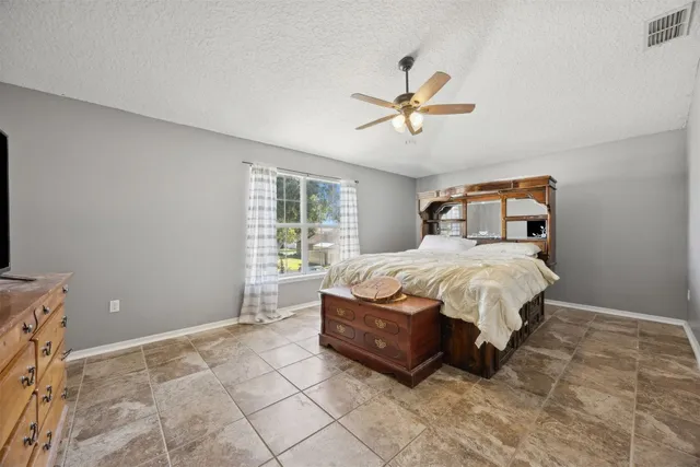 a bed sitting in a bedroom and chandelier