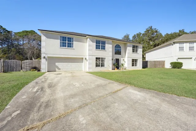 an aerial view of a residential houses with outdoor space and trees