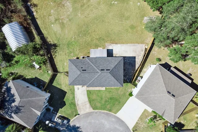 an aerial view of residential houses with outdoor space and trees
