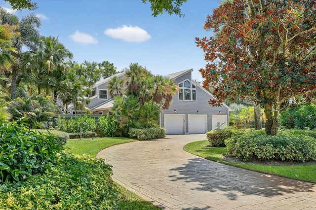 a view of a house with a small yard and a tree