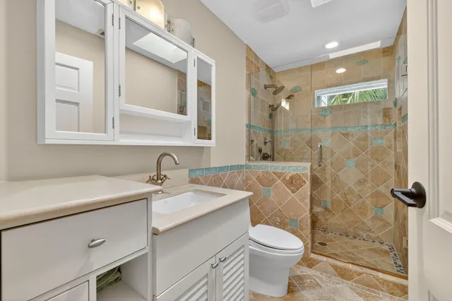 a bathroom with a sink mirror vanity and toilet