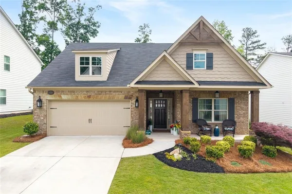 a front view of a house with a yard outdoor seating and garage