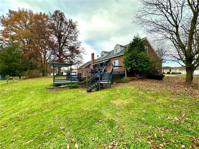 a view of a house with backyard and sitting area
